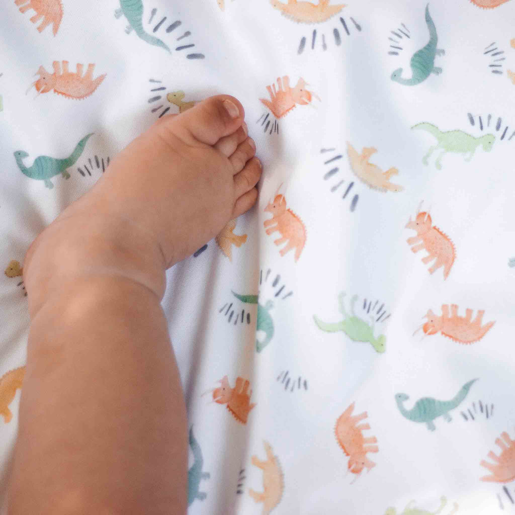 Baby's foot on a dinosaur travel changing mat