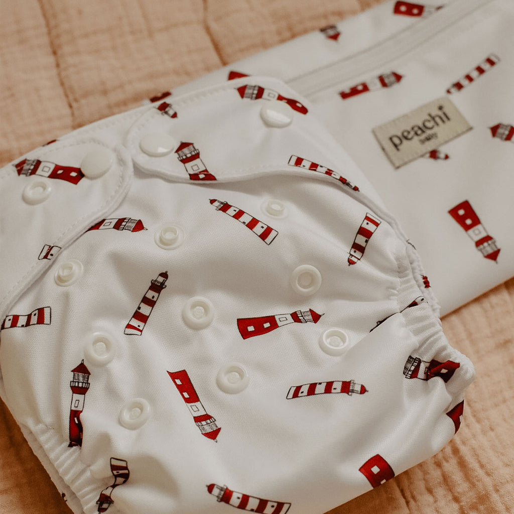 a lighthouse print modern cloth nappy with matching mini wetbag