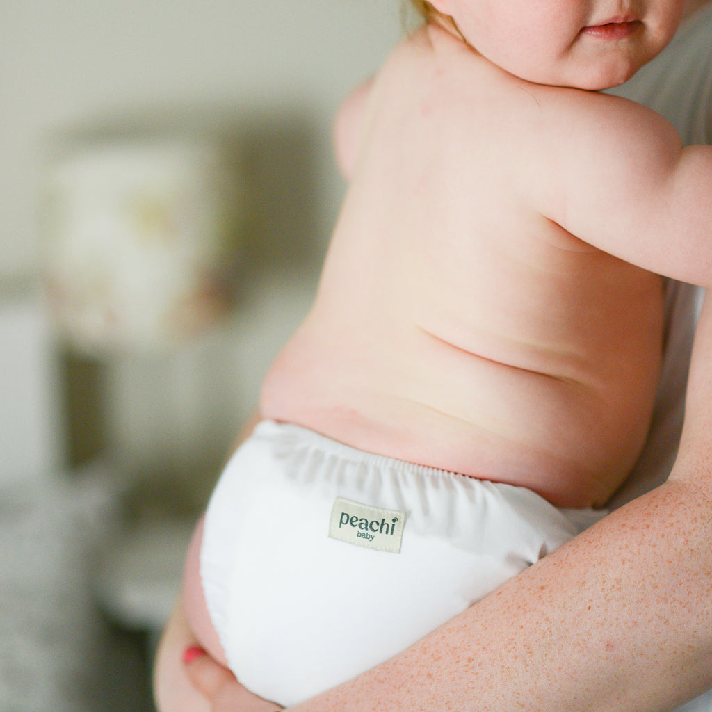 toddler wearing a white modern reusable nappy by peachi baby