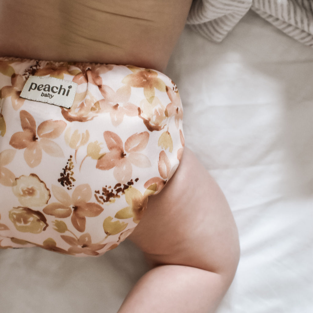Baby girl wearing a Zahra floral modern reusable nappy by Peachi Baby