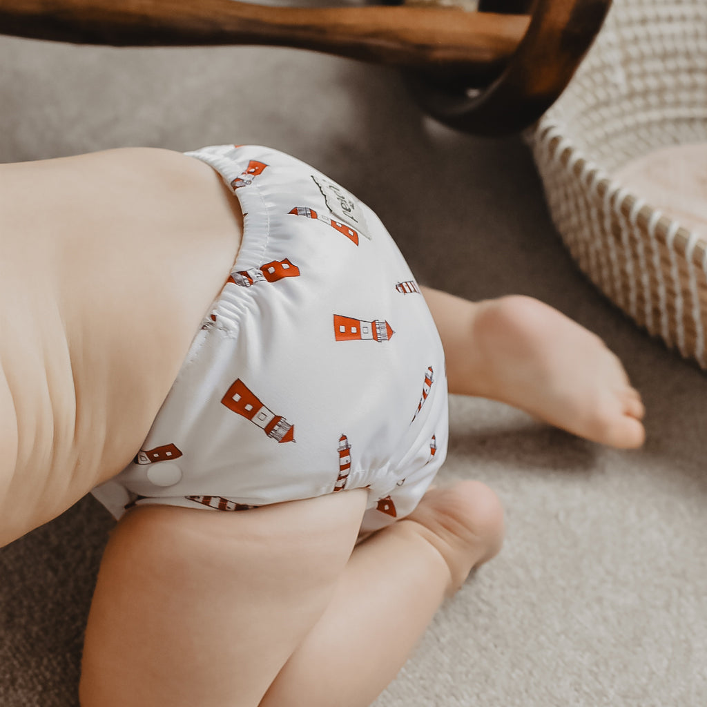 crawling toddler wearing a lighthouse print modern reusable nappy