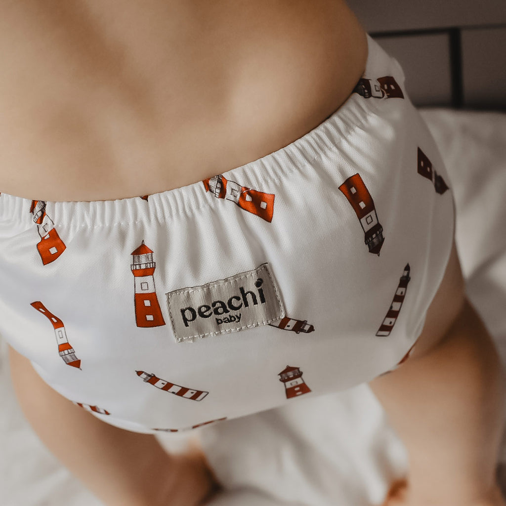 toddler wearing a a lighthouse print modern cloth nappy