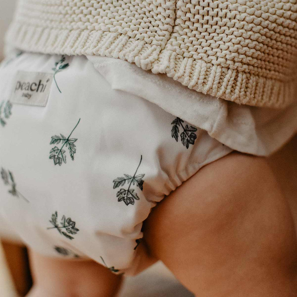 Baby wearing a Parsley print modern cloth nappy by Peachi Baby