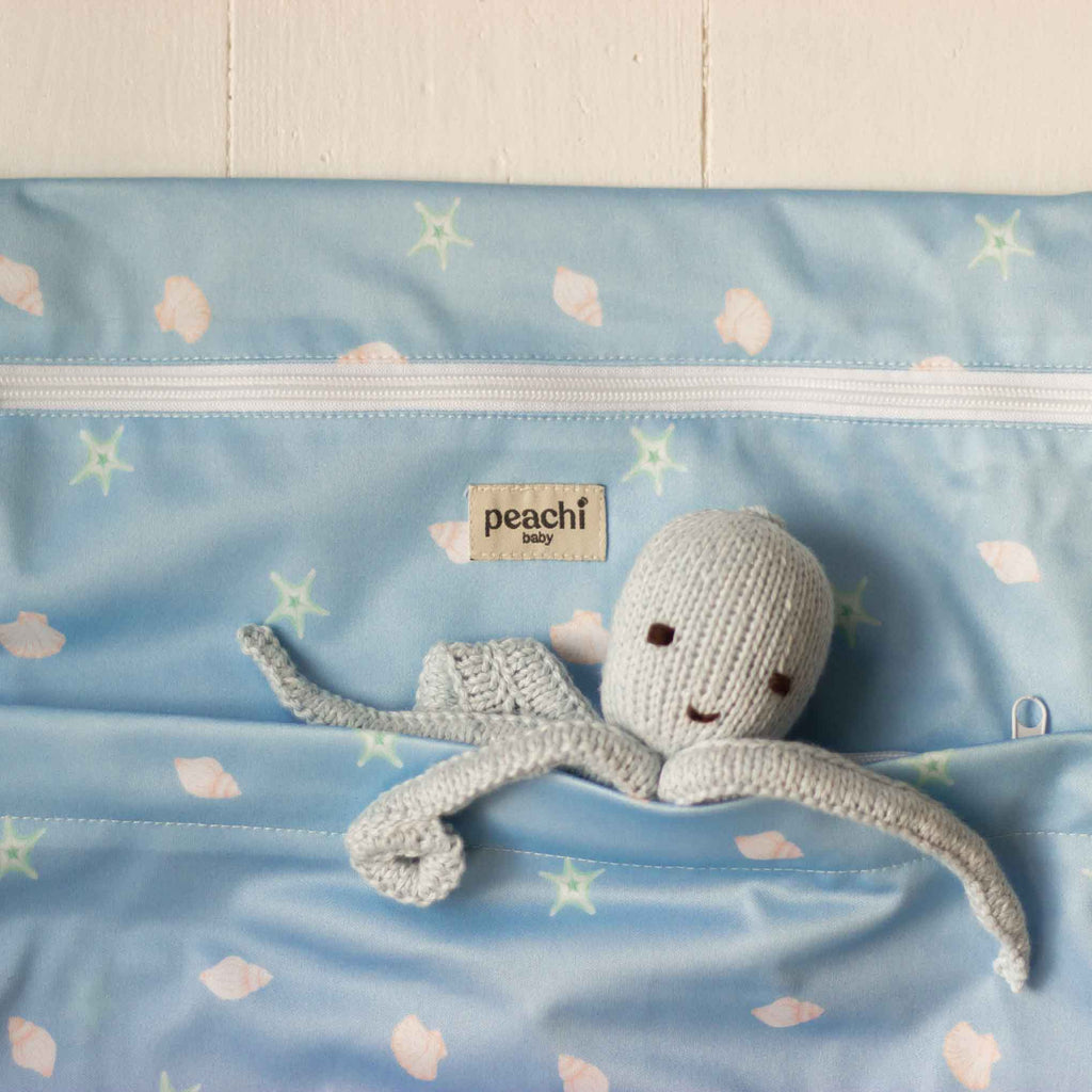 baby blue seashells print wetbag by peachi baby. pictured with a octopus in the pocket